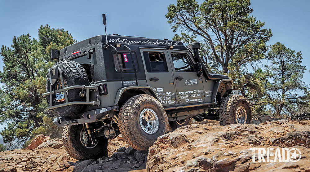 Gray overlanding Jeep climbs a rocky hill in Big Bear, California.