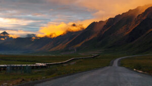 A midnight sun view of Alaskan Brooks Range mountains along with Trans-Alaskan Pipeline system near Atigun Pass and Gate of Arctic National park, Dalton Highway, Alaska.