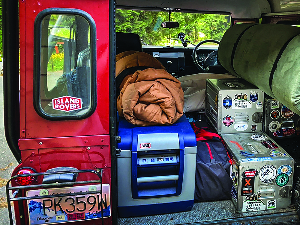 A glimpse inside the trunk of the Defender features a small fridge and storage gear.