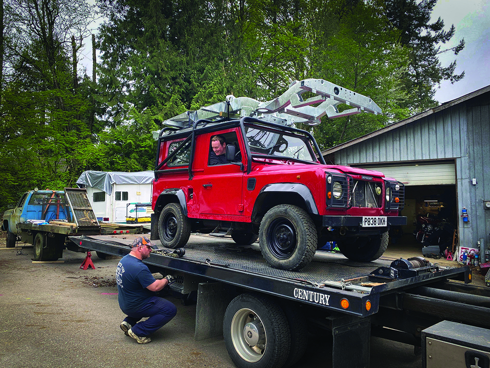 The red Defender waits to roll off the shipping truck.