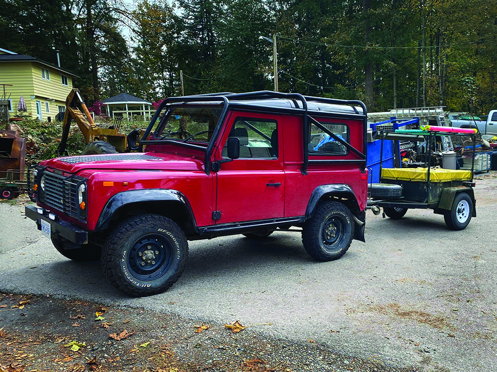 The red Defender hauls a small trailer.