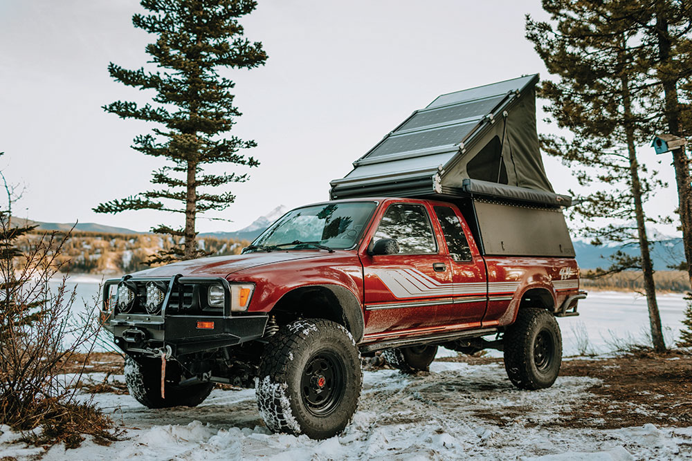 The Pickup's red paint shines against a winter landscape.