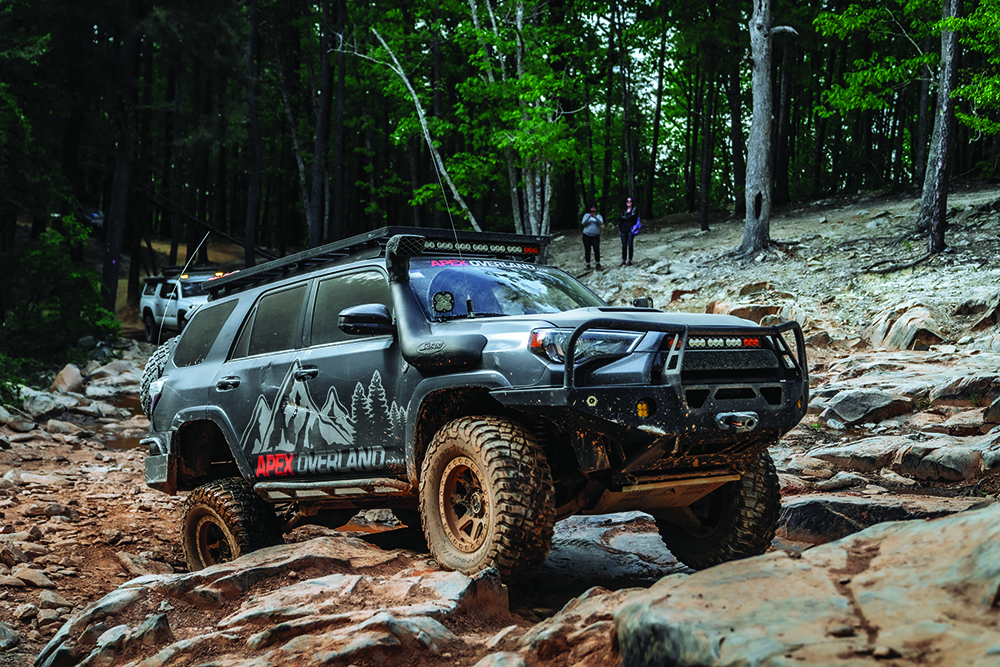 The black 4Runner crawls over rocks.