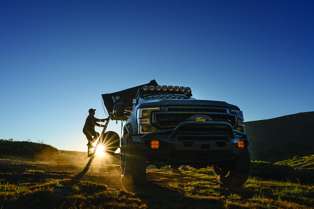 Mike scales the ladder to the RTT on the F250 Tremor.