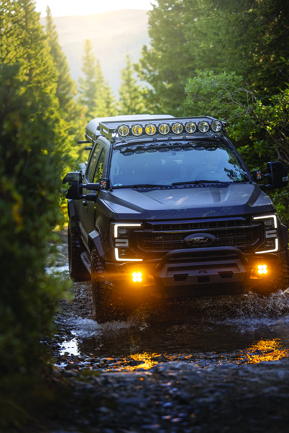 The F250 lights up the trail ahead as the sun sets.
