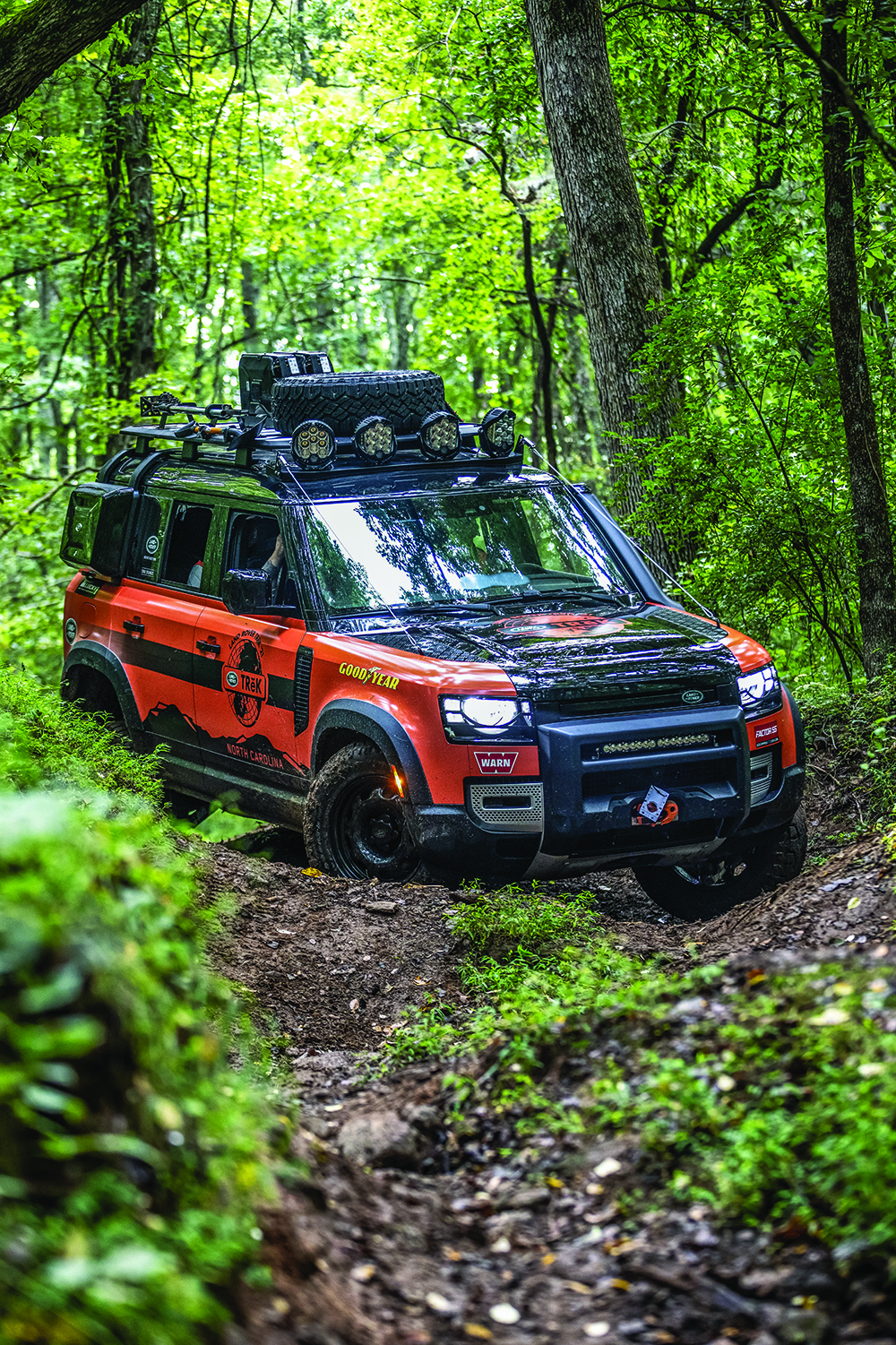 2021 Land Rover Defender 110 driving driving in very uneven and slippery terrain at the Biltmore Estate in the Land Rover TReK 2021 competition.