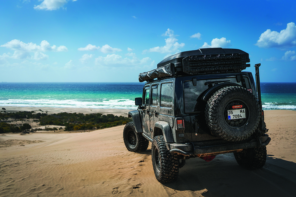 A Jeep sits on a sandy beach in Turkey