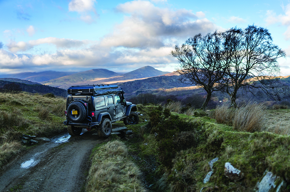 A Jeep drives down a trail in Snowdonia National Park, Wales