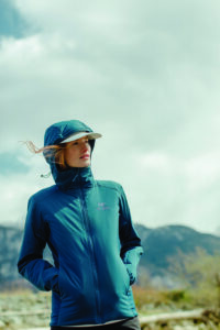 A woman outdoors wears blue performance clothing.