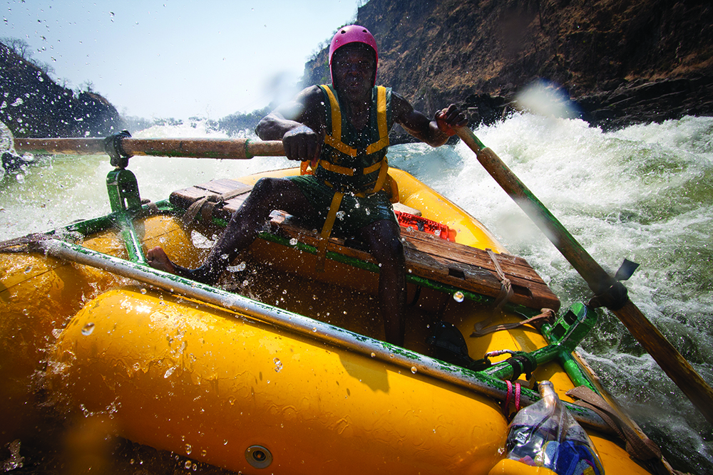 Rafter steering through white water