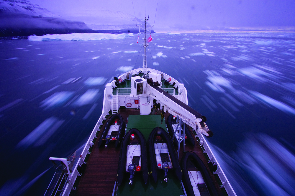 Action photography of a boat drifting through icebergs