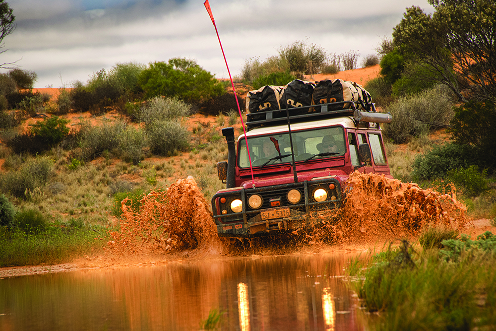 A Truck running through muddy waters 