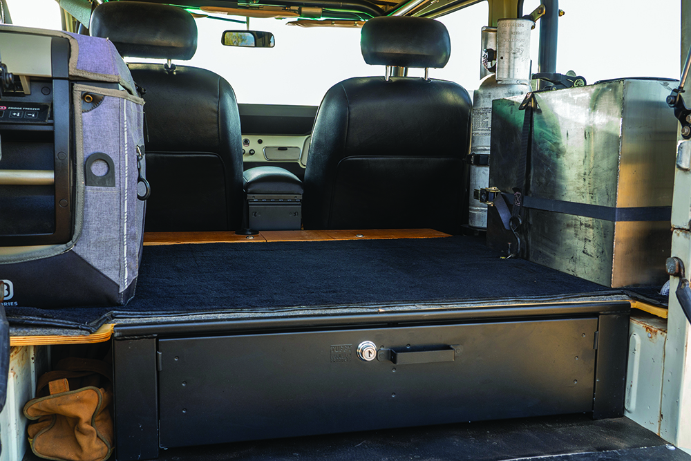 The FJ40's cargo area has a drawer, fridge, and water and propane tanks.