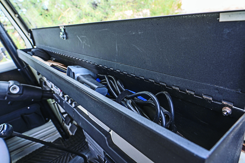 A black storage box holds small items on the dash.