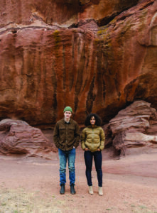 Two hikers pose for a photo in their performance denim.