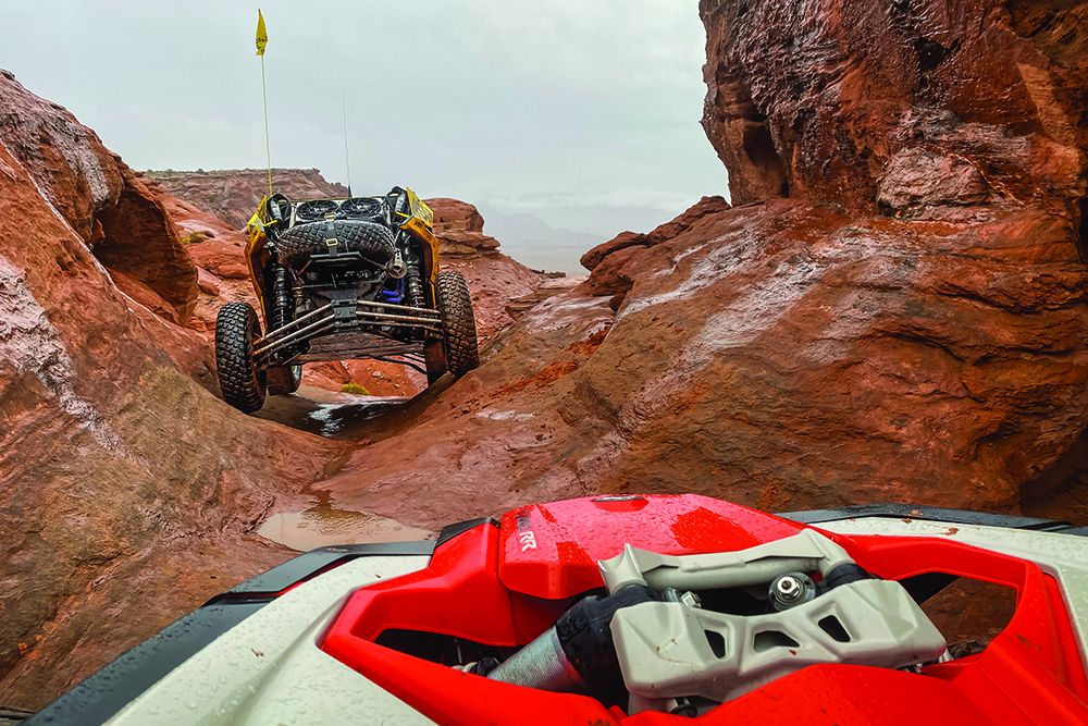 From the driver's perspective, another UTV climbs through tight trails.