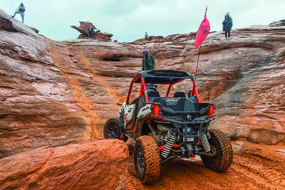 The author waits to climb a steep vertical in his red UTV.