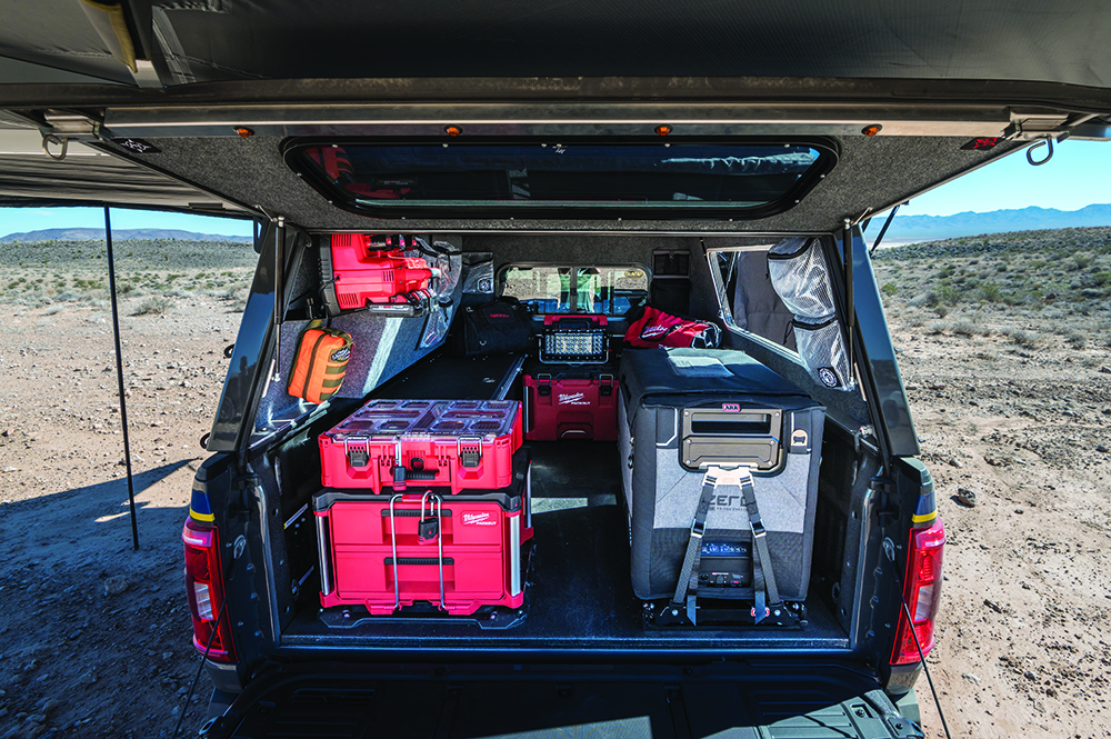 Organized storage, an ARB fridge, and seating fill out the truck bed.