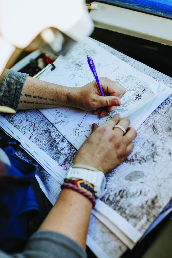 Navigator using a map, compass, and road book to continually plot their way to the finish line.