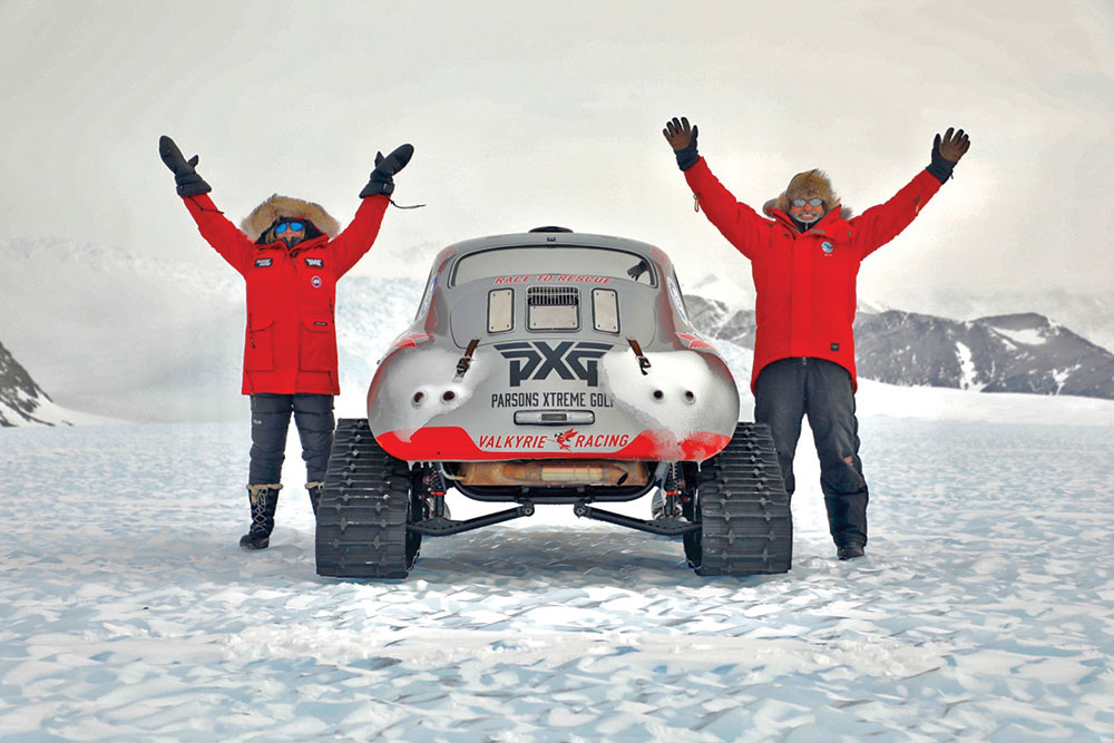Valkyrie Racing team memebrs in red coats celebrate next to the Porsche 356.