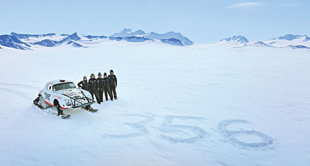 The Valkyrie Racing team poses next to the Porsche in a wide shot that shows the numbers "356" traced in the snow.