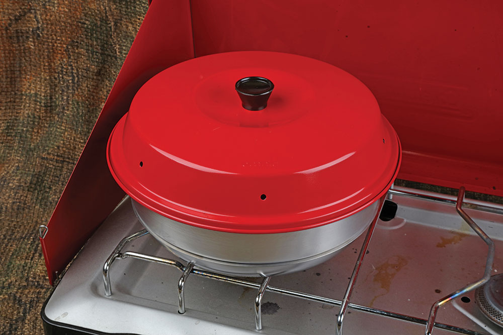 The red lid rests on the metal stovetop oven.