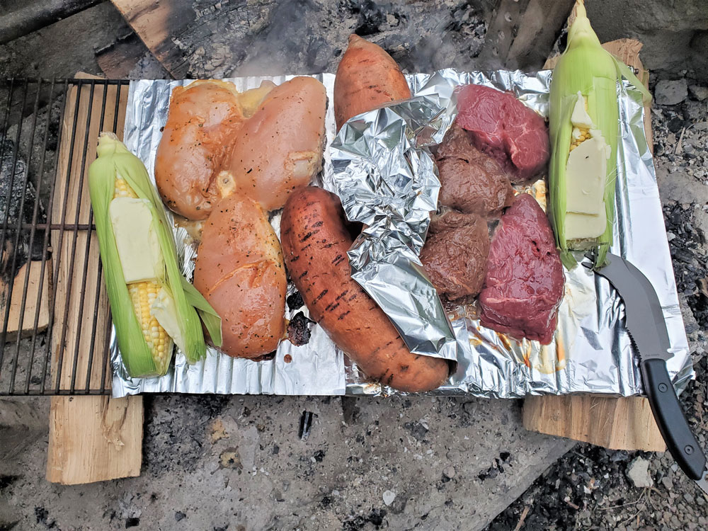 Corn, chicken, sweet potatoes, and steaks make the perfect campsite cuisine.