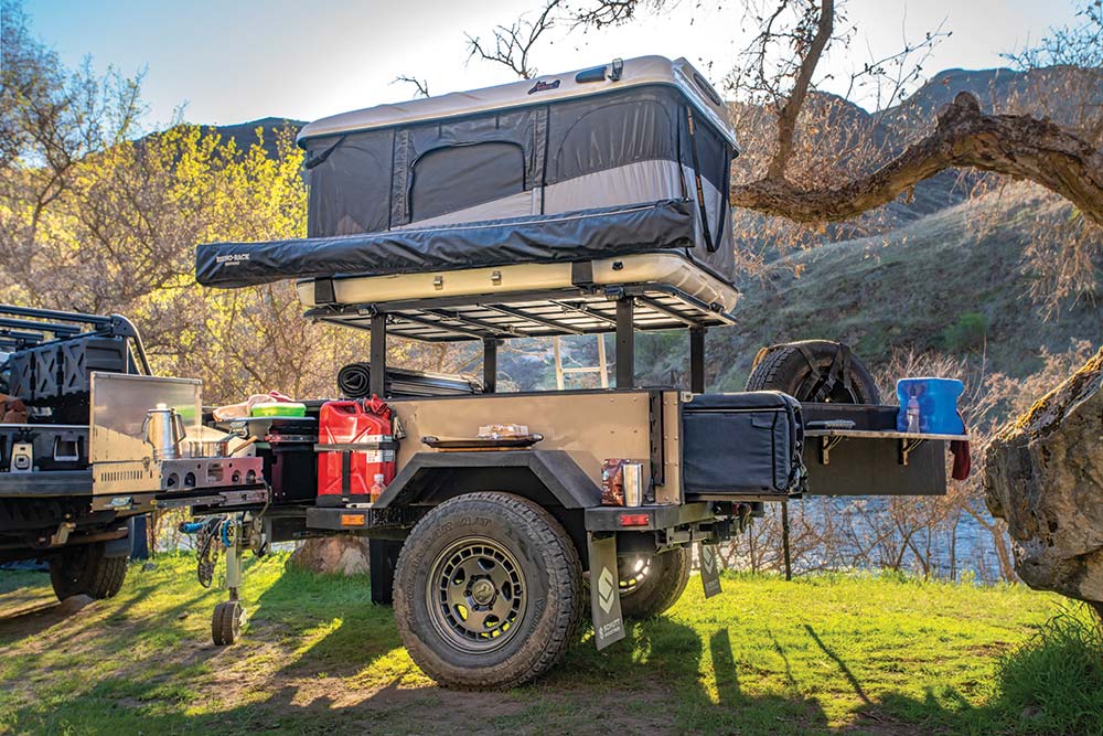 The trailer attached to the Tacoma holds a roof top tent and kitchen setup.