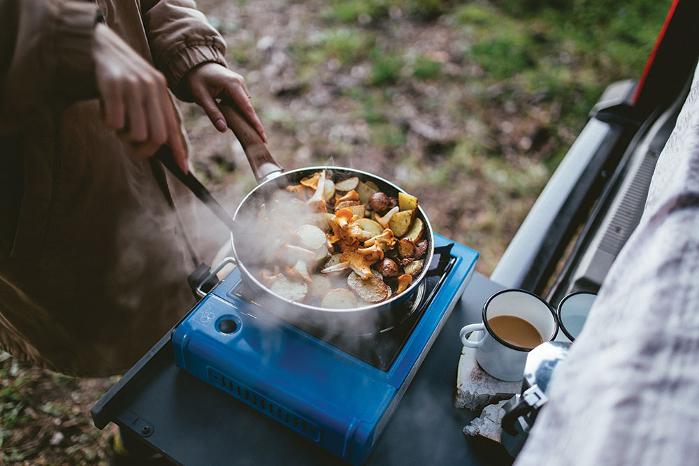 A single burner stove on the tailgate of an overland vehicle.