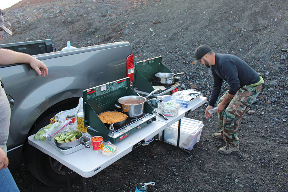 A folding table and two camp stoves comprise this overland kitchen.