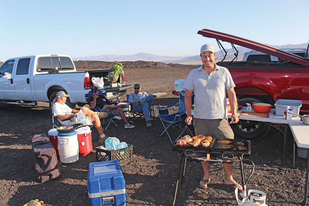 A man cooking in his overland kitchen. 