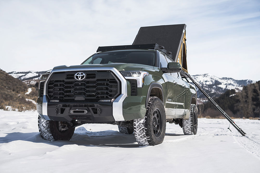 A green Tundra with beefy black front offroad bumper.