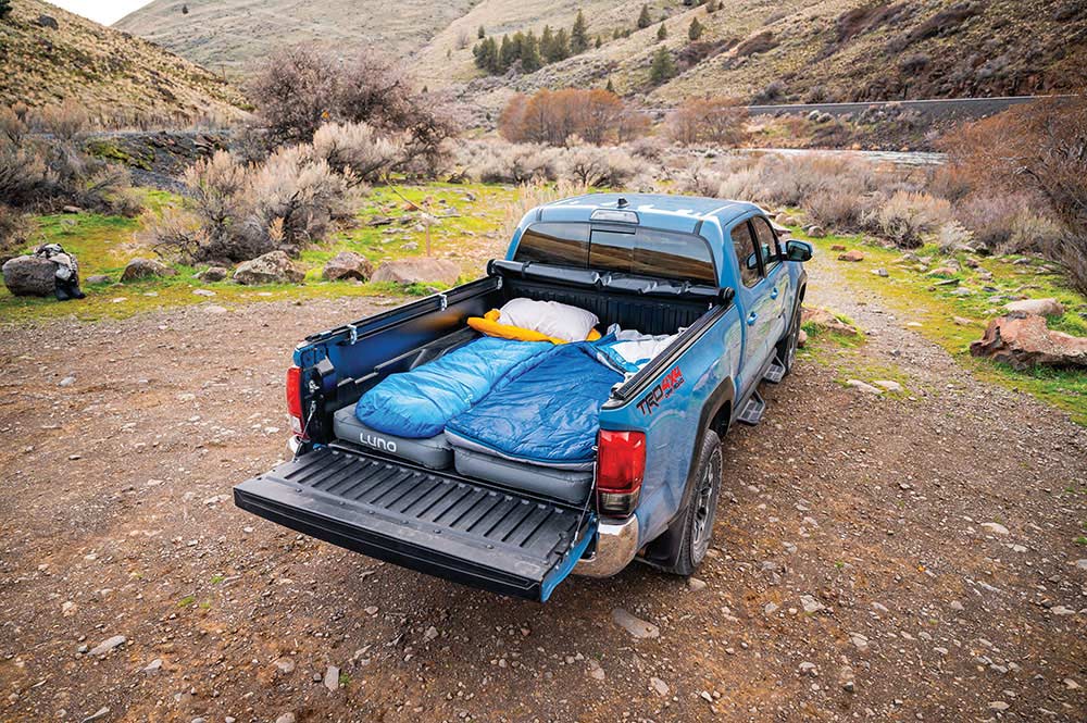 The air mattress gets cozy with accessories like sleeping bags and pillows.