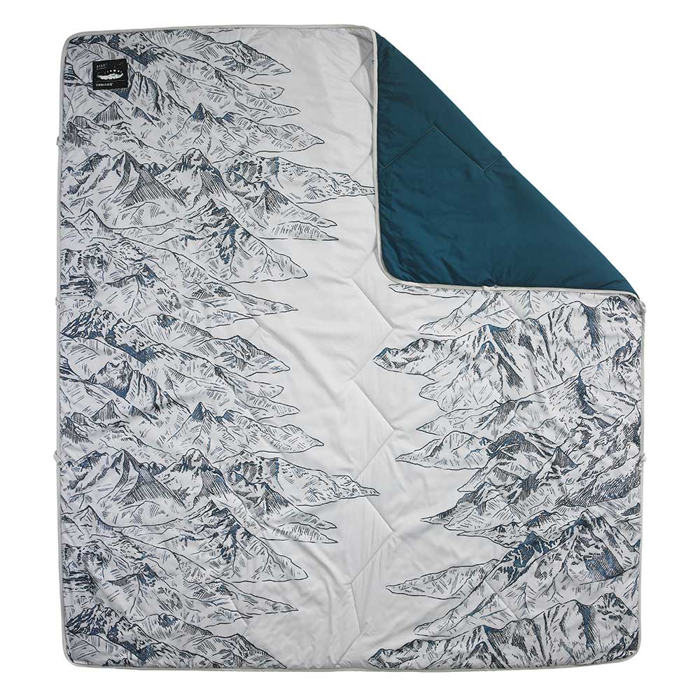 a white blanket with mountains and a dark green flip side, family gear 