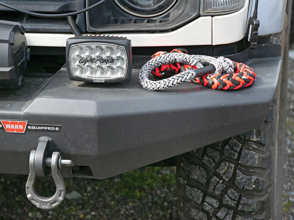 The black front bumper from WARN holds hooks, tow rope, and lights on this vehicle.