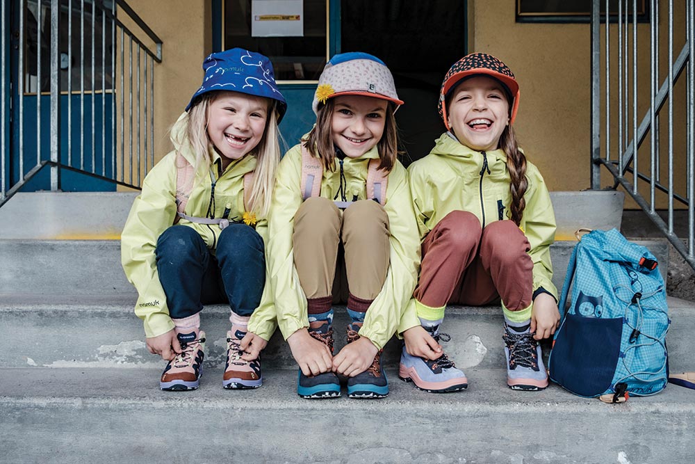 Three little girls sitting on the steps and laughing 