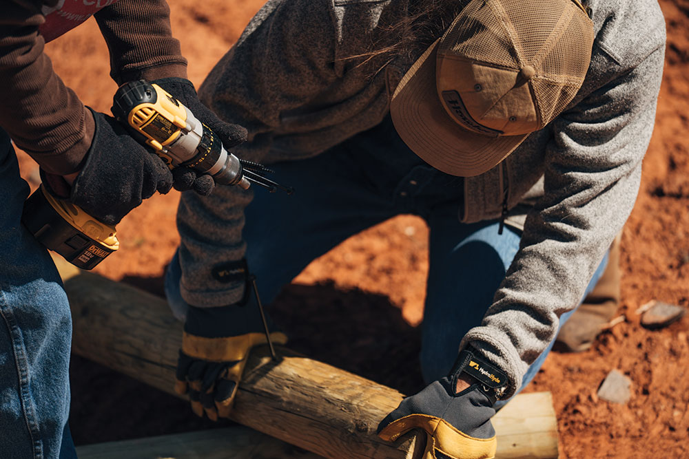 Tread Lightly! volunteers drill holes into fence posts.