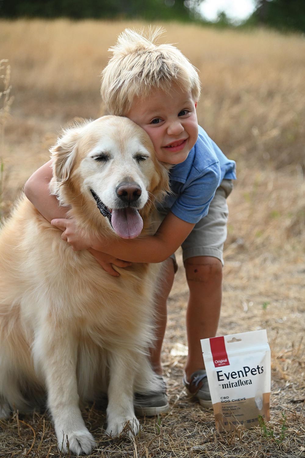 A boy hugging his dog with the EvenPets dog chews
