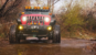 Red Jeep drives through creek on Steal Bender Trail in Moab, Utah.