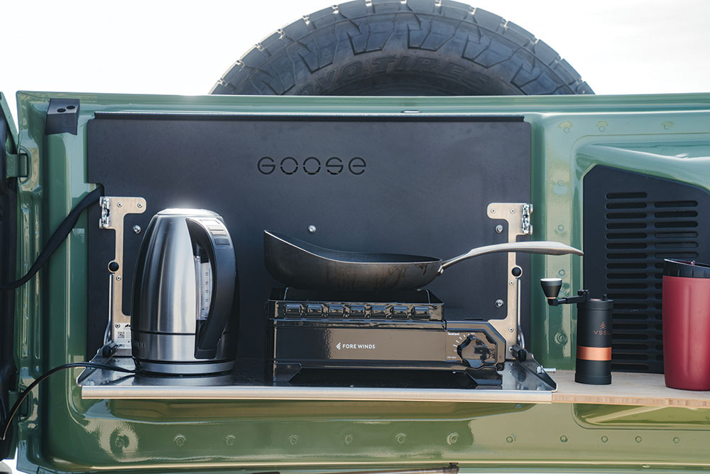 The Bronco kitchen setup features an electric kettle, one-burner stove, and black Goose Gear drawers.