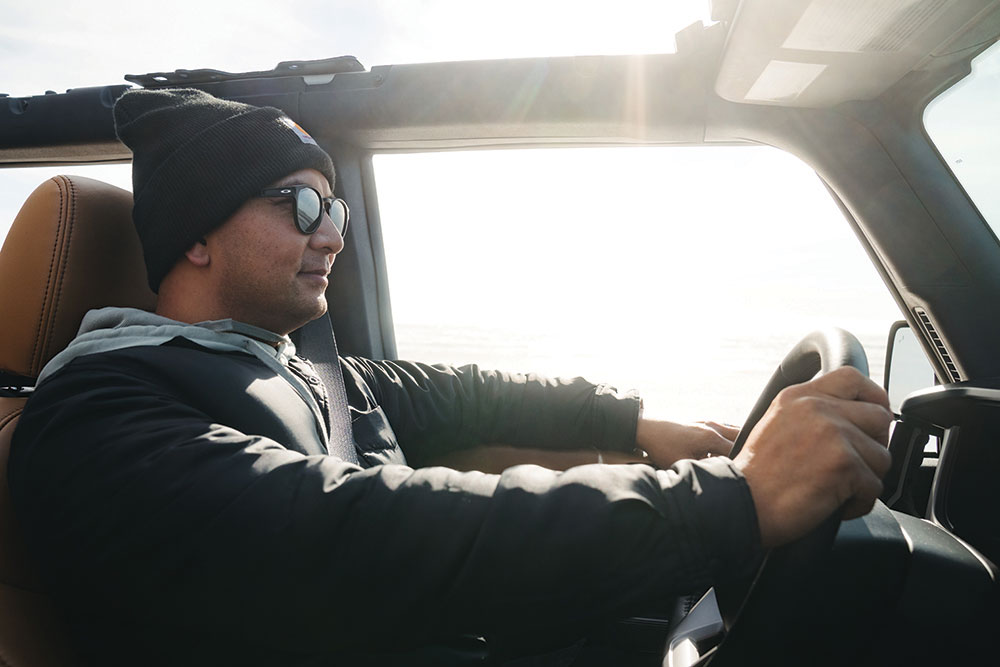 Pangilinan wearing a black jacket, sunglasses, and a black beanie, drives.