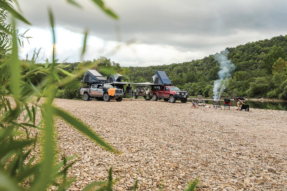 The Mountain State Overland crew circled up and camping beside a body of water 