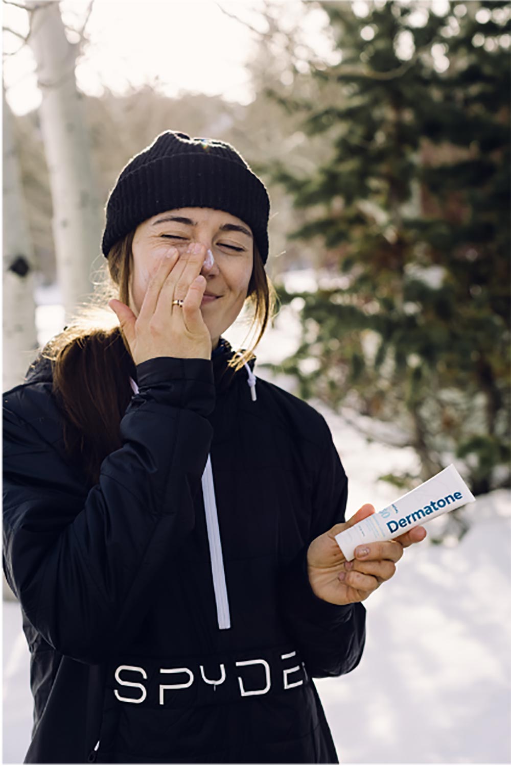 a woman putting on dermatone sunscreen 