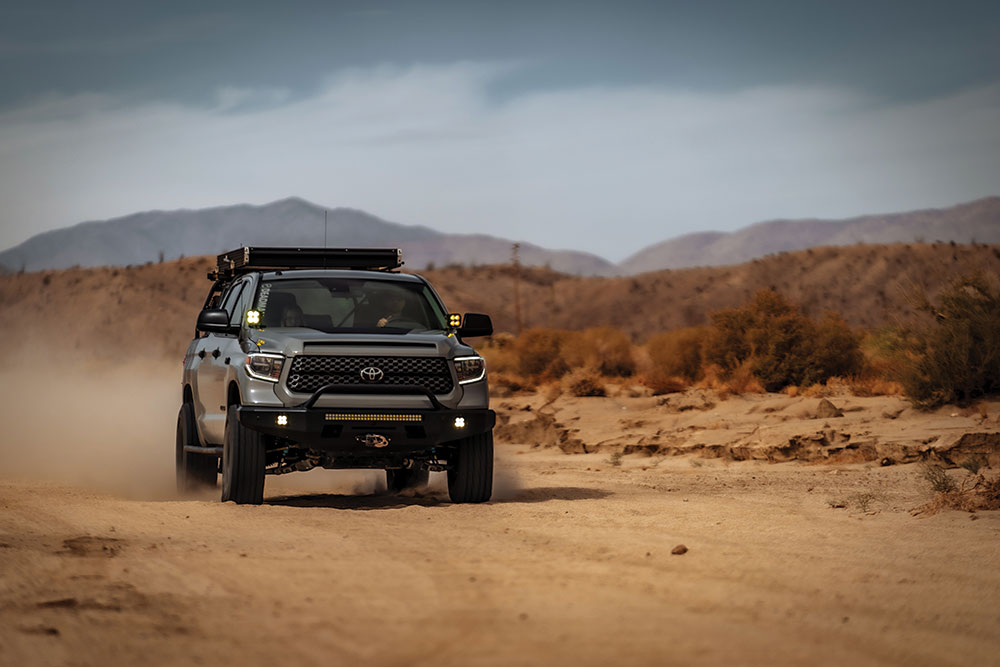 The Tundra whips up a dust cloud under gray desert skies.