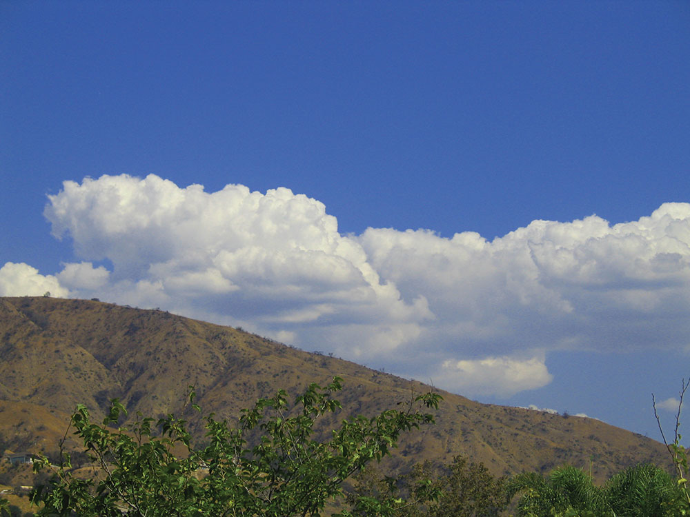 Huge, puffy white clouds against a bright blue sky.