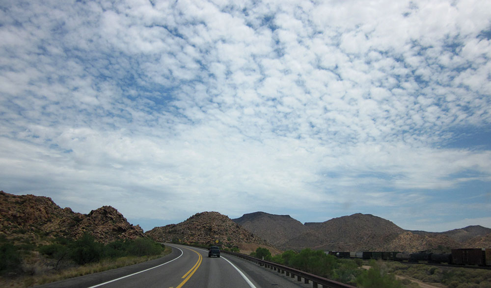 A thin, high-altitude cloud veils the sky with a layer of gray cover.