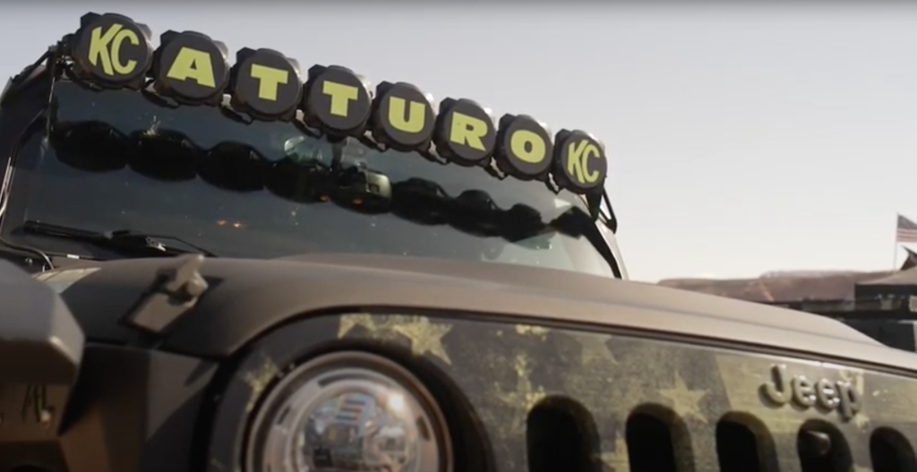 Front end of a black Jeep with Atturo light covers on KC Hilites lightbar.