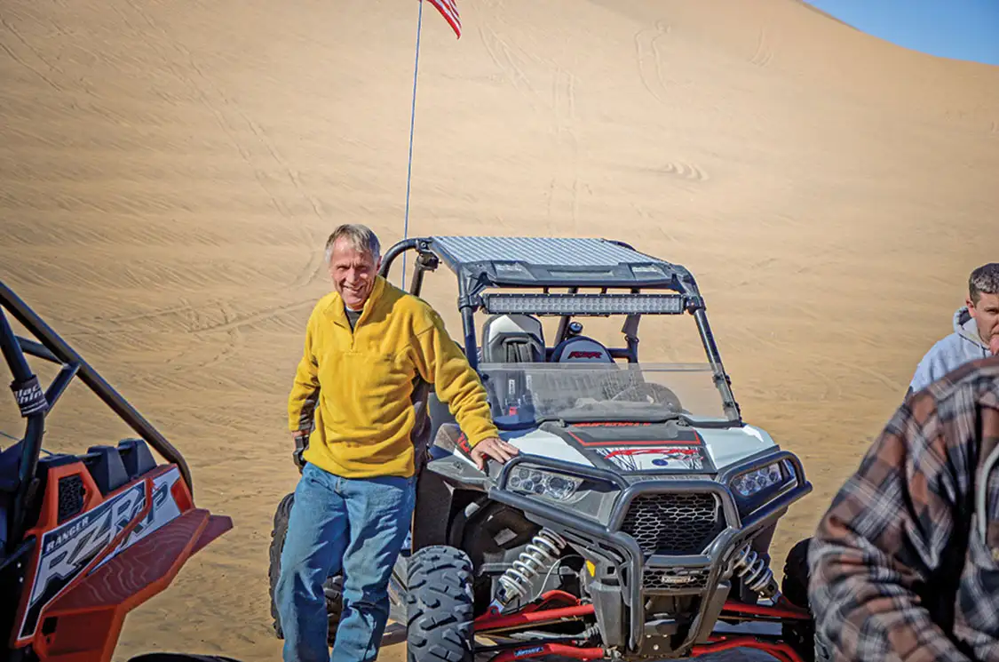 Harold Hunt stops for a picture while riding his RZR in the dunes