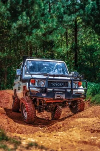 Students build a makeshift bridge to cross a log higher than the Hilux’s breakover angle