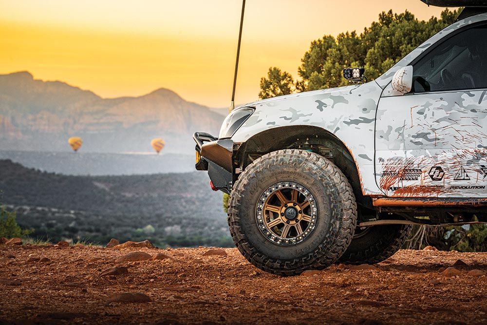 The front half of the GX470 features a black metal grille, large tires, and custom badging.